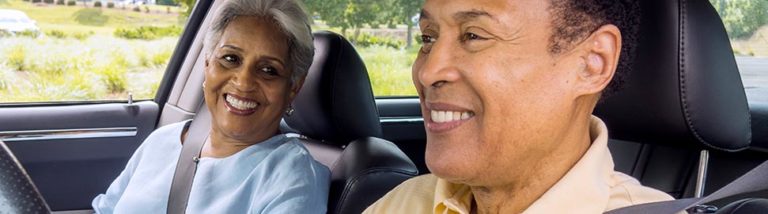 Older couple driving together in car